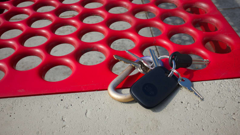 Tile's Pro tracker, attached to a set of keys, laying atop a bus stop bench.