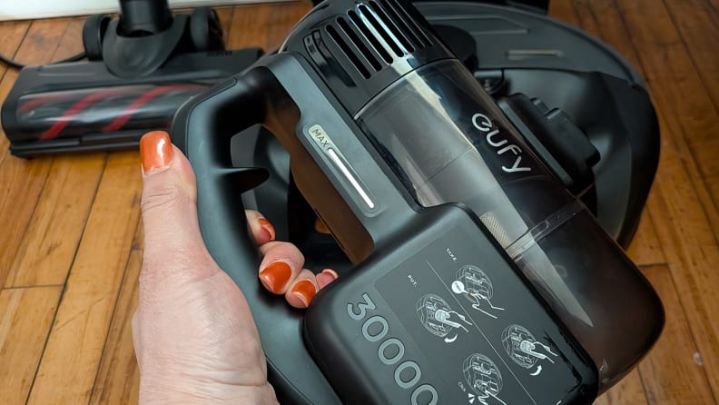 A hand holding a hand-held vacuum