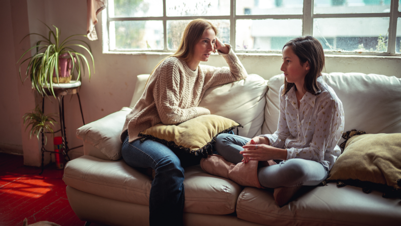 Mother and daughter having a conversation on a couch