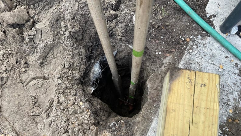 A hole on the ground being worked on to install posts.
