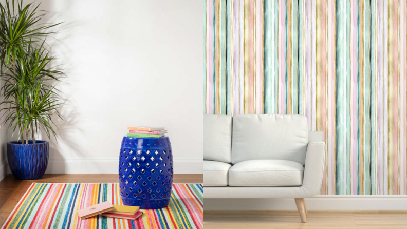 On left, multi-colored striped rug on floor under round, blue ottoman and potted plant. On right, cream couch in front of colorful wallpaper.