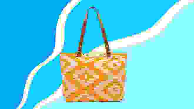 A printed yellow handbag against a blue background.