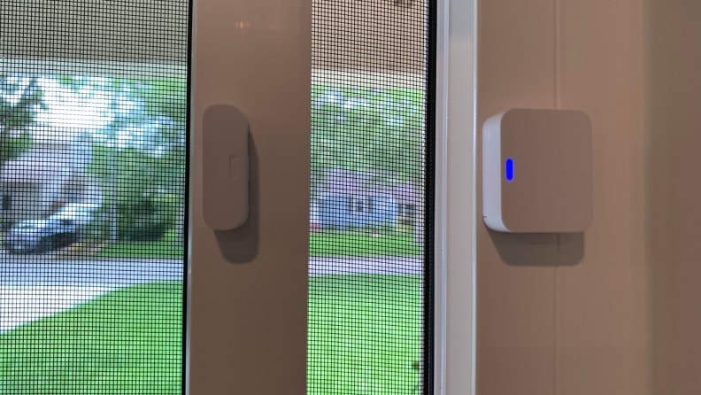 A SimpliSafe entry sensor installed on an open window.