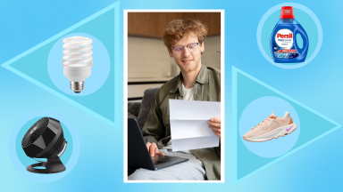 Black fan next to twister light bulb, person smiling while looking at document in front of laptop, blue bottle of laundry detergent and pink walking sneaker.