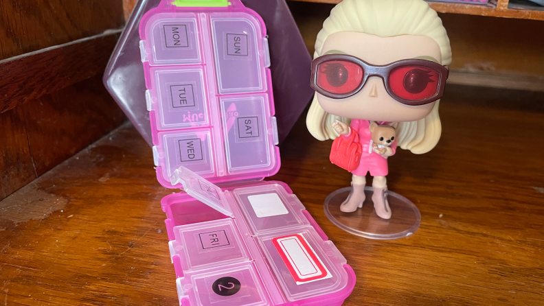 The M MUchengbao Travel Pill Organizer next to a Funko Pop figurine