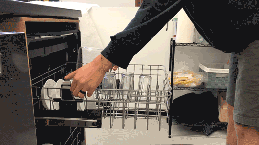 A gif showing a lab technician adjusting the dishwasher's upper rack vertically.