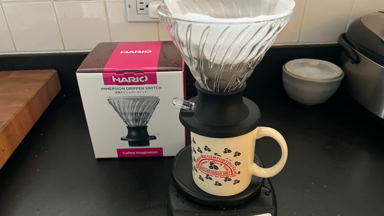 The Hario Switch on coffee mug next to product box