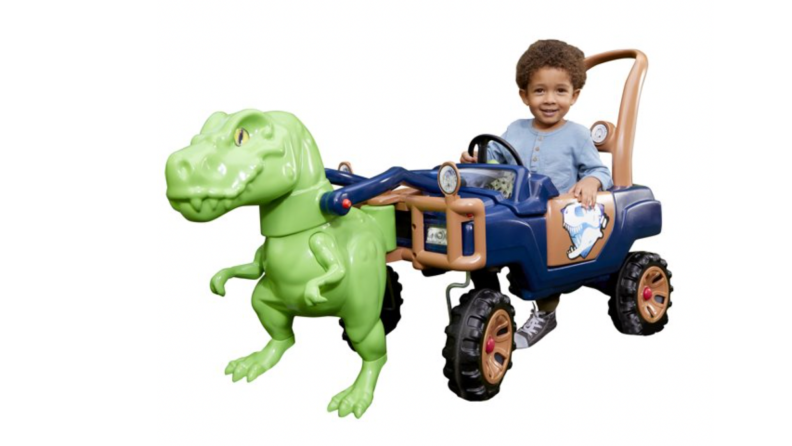 A child rides a dinosaur peddle car