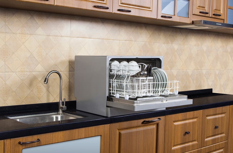 A countertop dishwasher sits atop a kitchen counter.