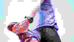 一个穿着紫色运动鞋的女人伸展她的四头肌。