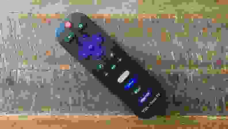 The Roku remote for a TCL 5-Series TV sittingon a wooden table.