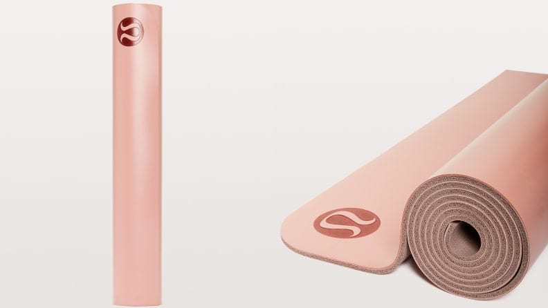 blush pink rolled yoga mat on grey background