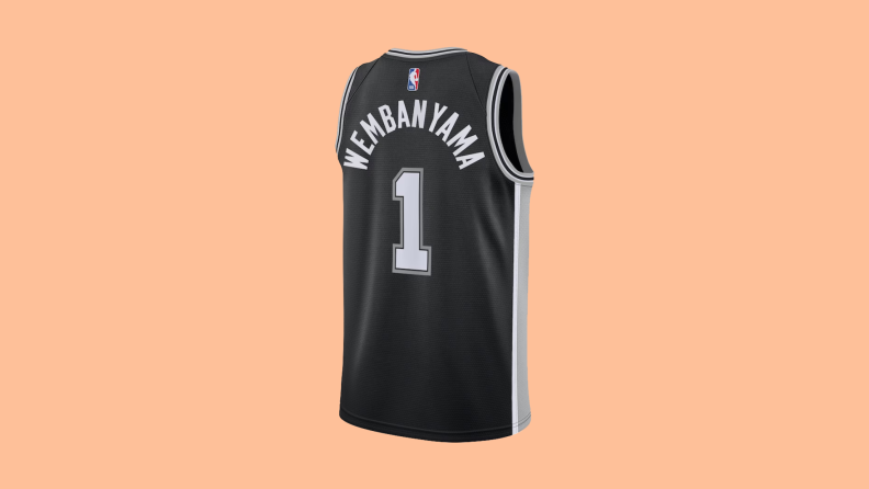 A San Antonio Spurs Victor Wembanyama jersey on an orange background.