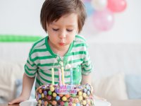 Boy blowing out birthday candles on cake