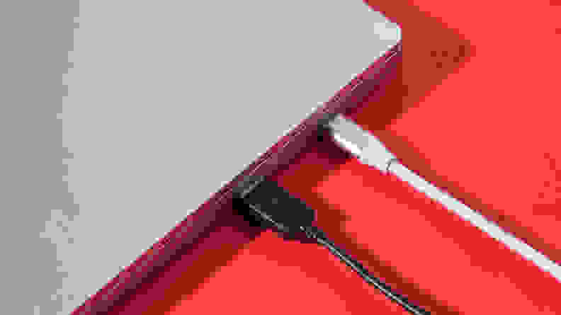 Close-up of the side ports of the laptop with two cables plugged in.