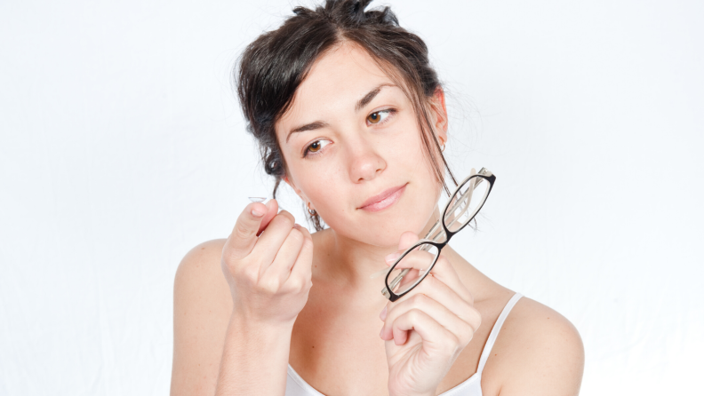 Woman holding a contact and glasses