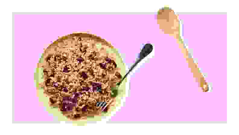 Dish of rice and peas and wooden spoon on purple background