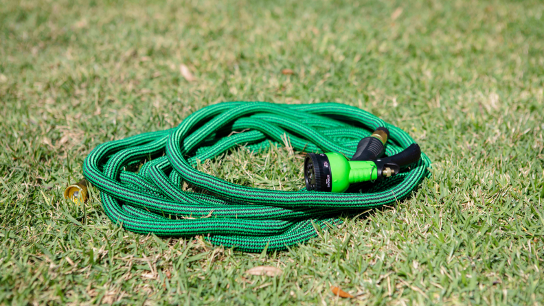A person sprayer the grass with a garden hose