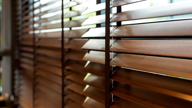 Tan, faux wooden blinds in front of window