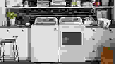 A GE top-load washer and its paired dryer in a modern laundry room.