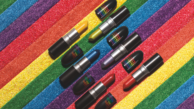 Multiple MAC Cosmetics lipsticks against a rainbow.