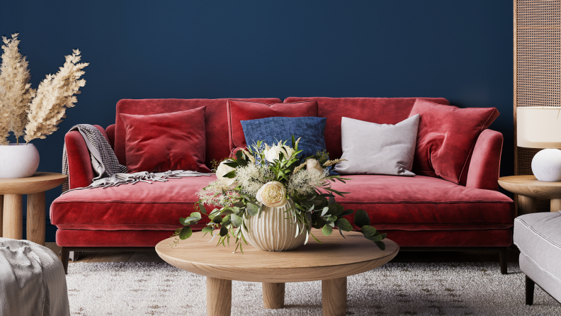 A red velvet couch in a blue living room.