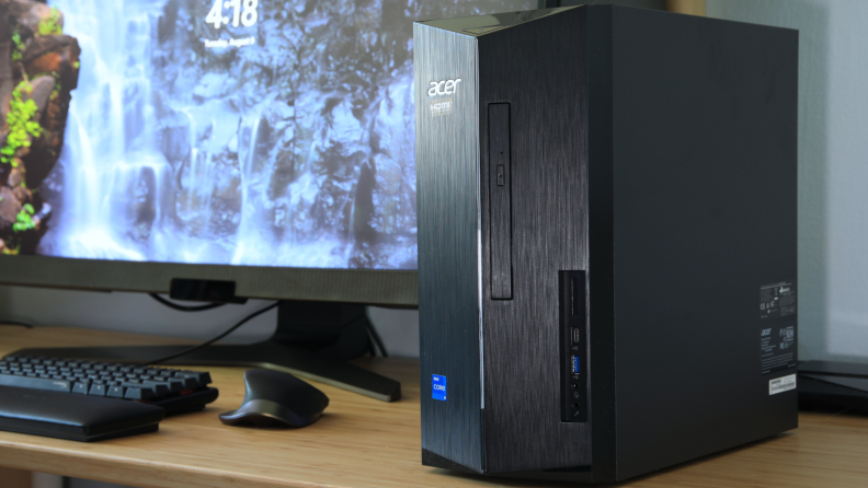 A black Acer desktop computer tower sits on a desk next to a computer monitor.