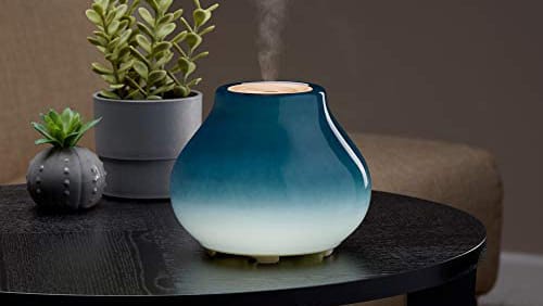 blue oil diffuser on wooden table