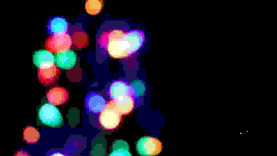Close-up, out-of-focus Christmas lights in a variety of colors: blue, red, green, orange.