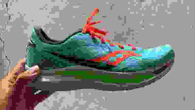 Hand holding Saucony Endorphin Speed running shoe in Spring / Future colorway.