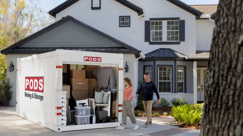 A large portable storage unit in front of a house