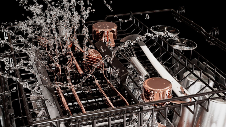 Dramatic still image of water sloshing above dishes in the top rack of the CAFE CustomFit Stainless-steel Interior Smart Dishwasher.
