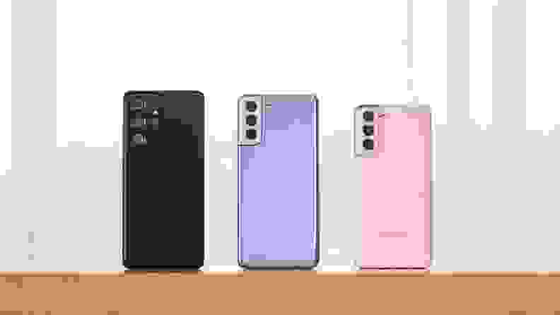 一部黑色，紫色和粉色的手机并排摆放