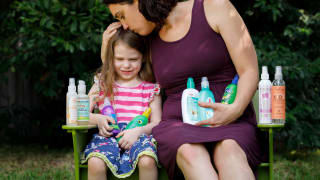 A mother using a great detangler for kids on her daughter's hair.