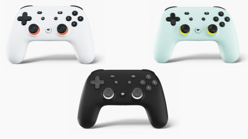 Three Google Stadia controllers in white, black and green shades.