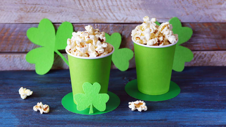 Green paper cups filled with popcorn.