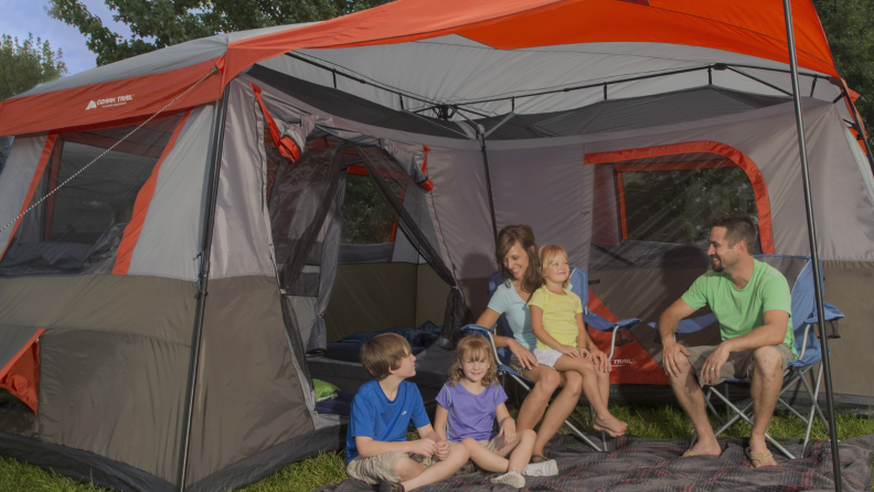 Family sitting in front of a large tent
