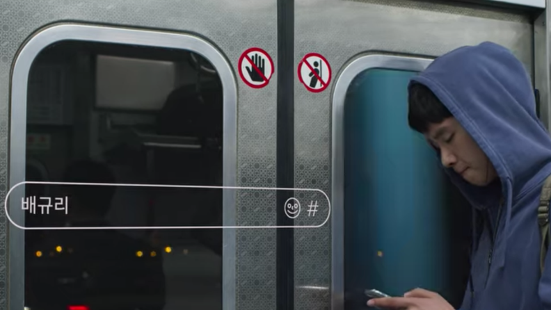 Boy on train texting on smart phone.