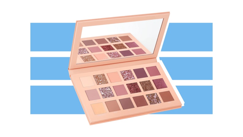 Huda Beauty The New Nude Eyeshadow Palette against a blue and white background.