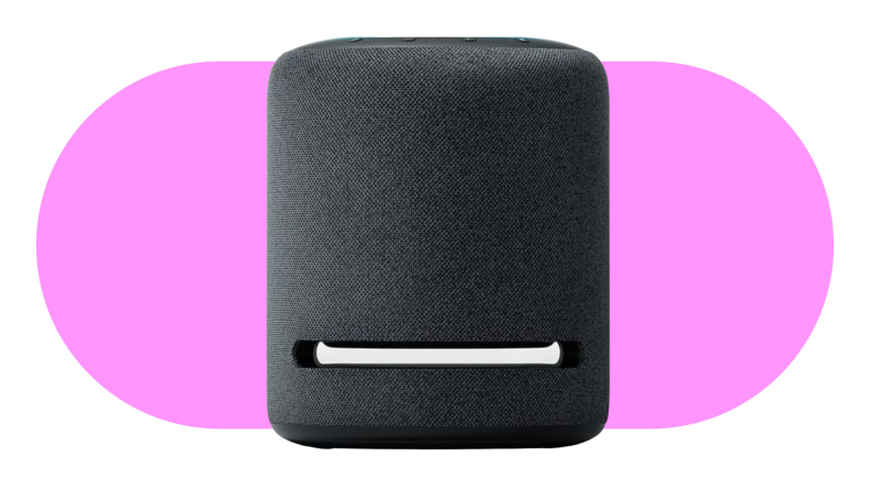 An Amazon Echo Studio device sits on a pink background