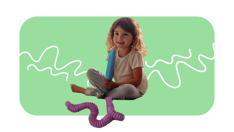 Small child sitting with legs crossed while playing with blue and purple pipe toys.