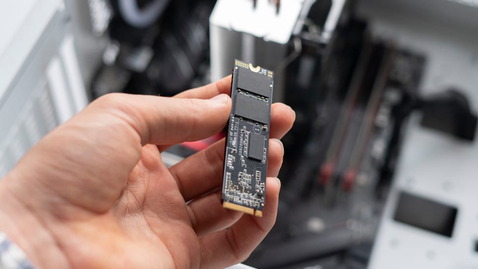 An M.2 SSD grasped between a person's fingers