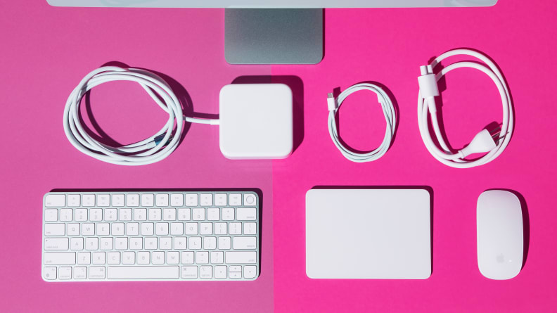 White computer peripherals arranged in a grid-like fashion on a hot pink background.