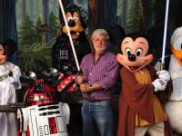 George Lucas posing  with disney characters