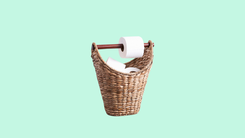 The Pottery Barn Seagrass Handcrafted Toilet Paper Holder in front of a background.