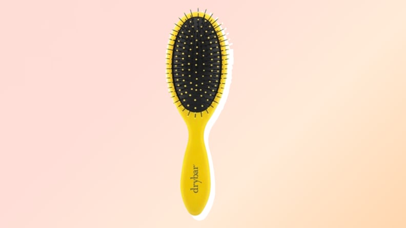 One of the best hair brushes from Drybar against a red and orange background.