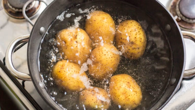 Several potatoes in a pot of boiling water
