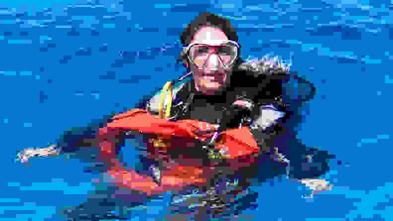 Person wearing diving gear in open body of water.
