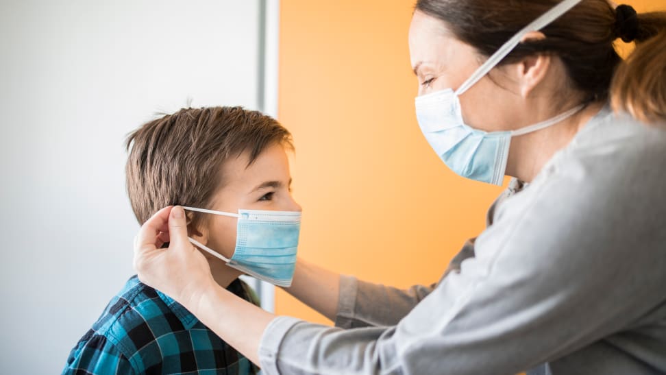 Mom putting a face mask on her son