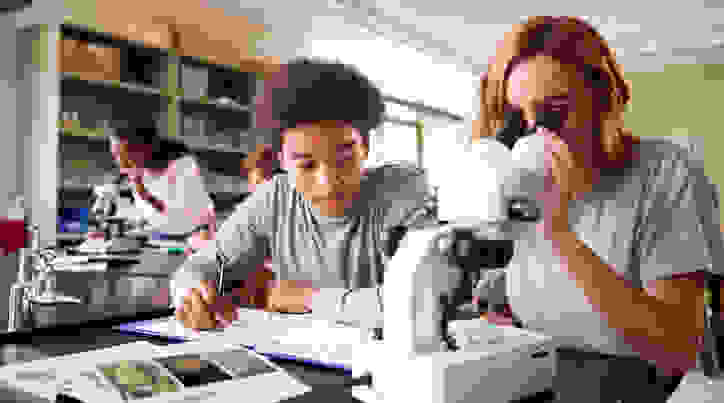 Kids in science class with a microscope